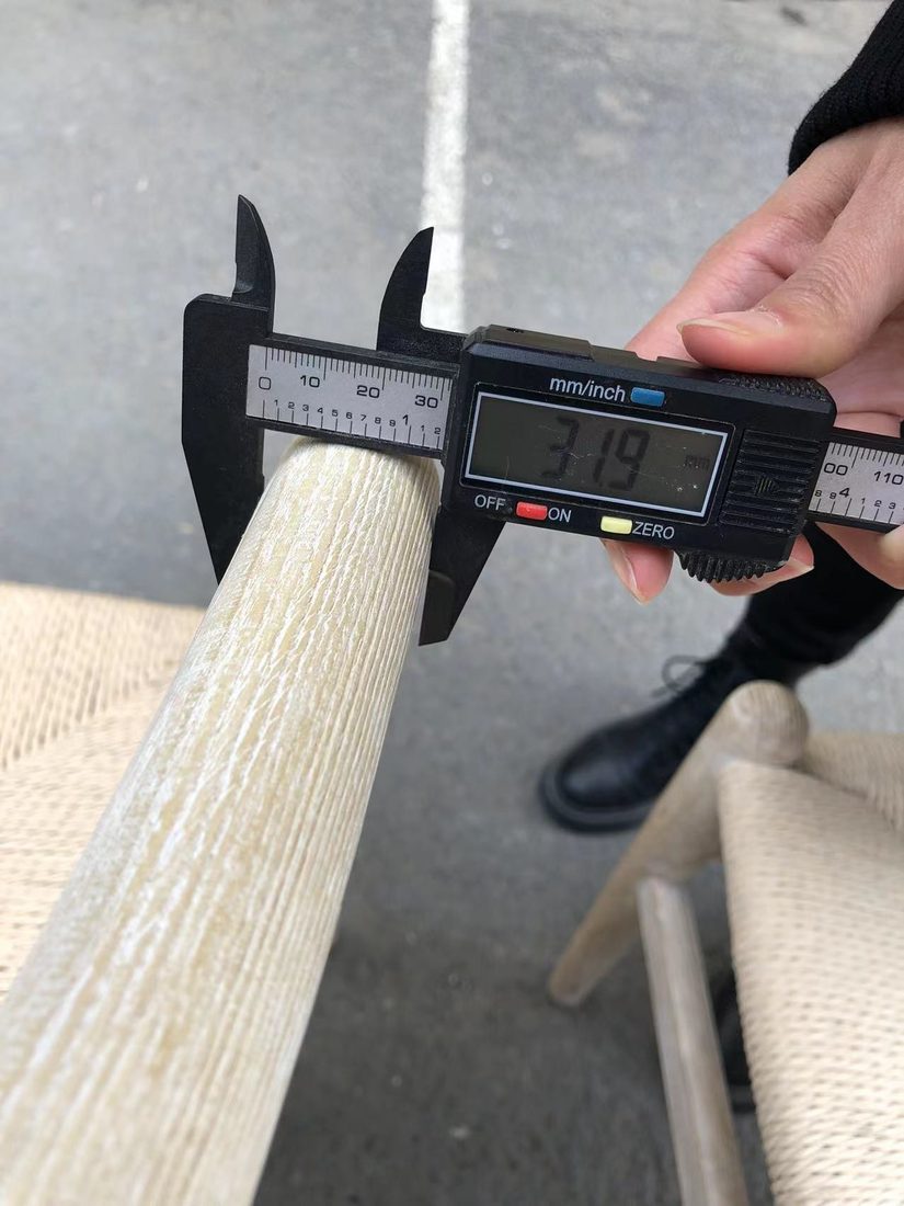Calibre digital midiendo el grosor de una pata de madera