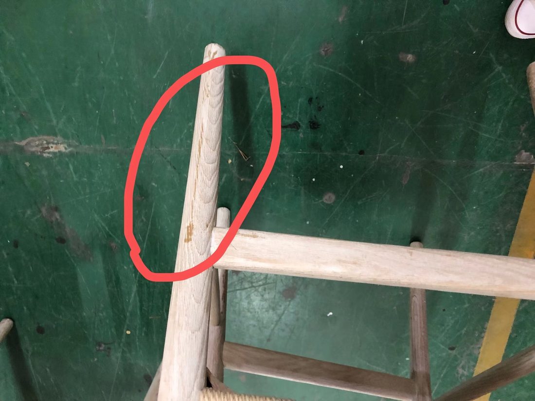 Defecto marcado en rojo sobre el respaldo de una silla de madera